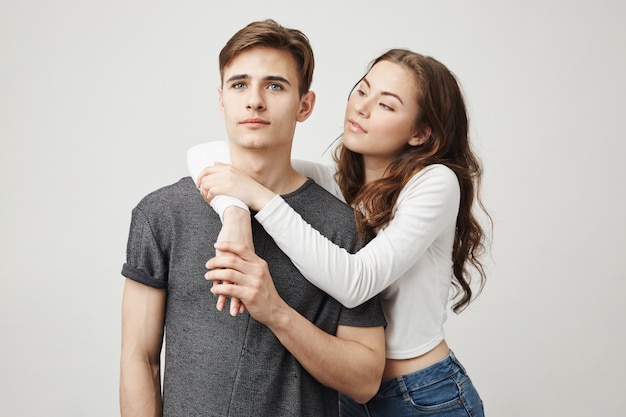 Girlfriend hugs his boyfriend from behind while he is dreaming about something.