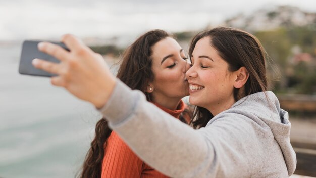 Selfieを取っている間ガールフレンドの頬にキス