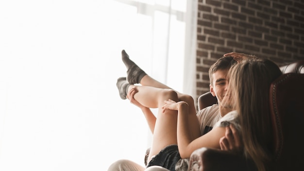 Girlfriend sitting on man's lap looking at each other