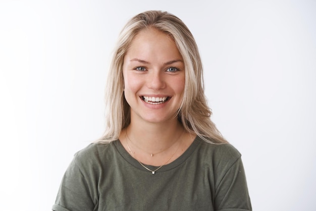 Girlfriend smiling feeling upbeat and happy laughing from love and amusement looking joyful at camera having funny conversation grinning pleasantly posing against white background