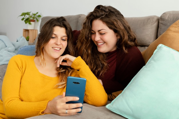 Girlfriends at home using mobile