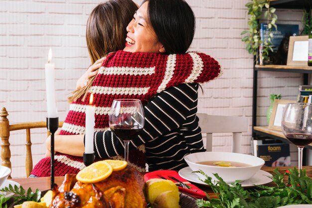 Amiche che si abbracciano alla cena di natale