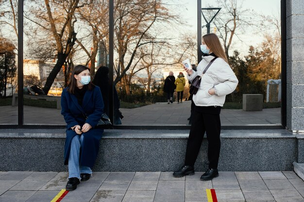 Girlfriends meeting at coffee while wearing masks