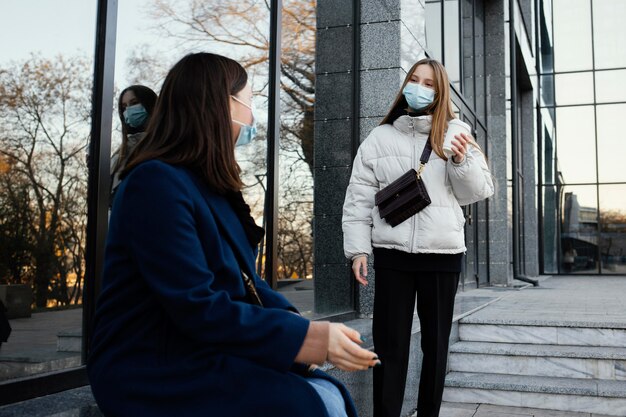 마스크를 착용하는 동안 커피에서 만나는 여자 친구