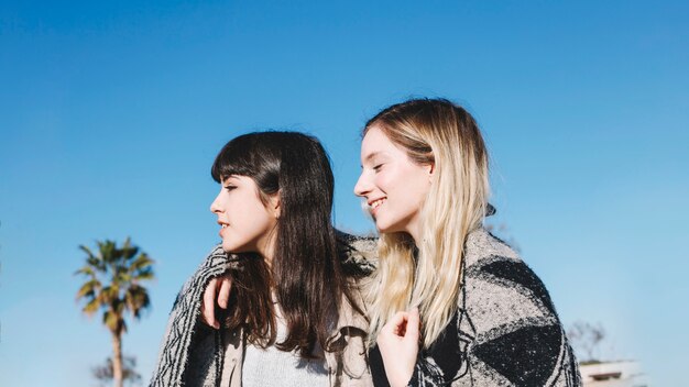 Girlfriends in plaid on blue sky