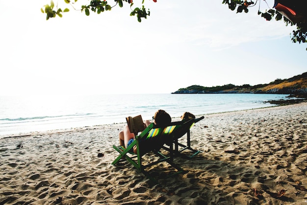 ガールフレンドはリラックスしてビーチで読書