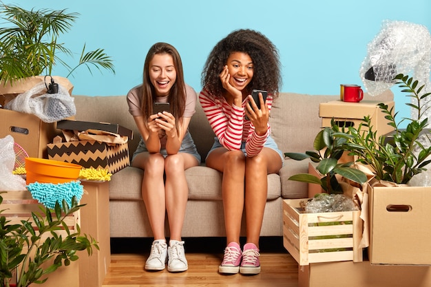 girlfriends sitting on the couch surrounded by boxes