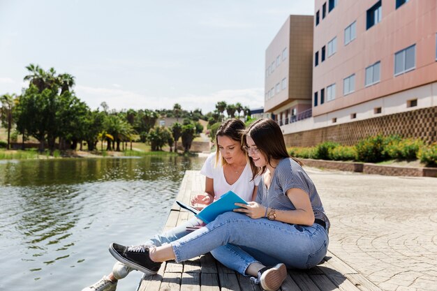 Girlfriends studying in campus near lake