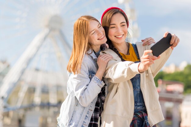 Girlfriends taking selfie at london eye