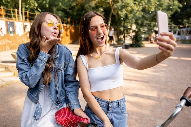 Girlfriends with bike taking selfies