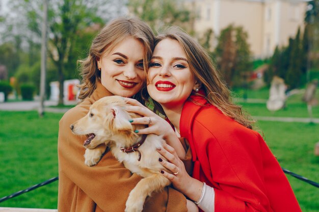 The girls are walking in the park with dog