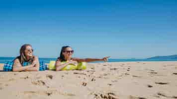 Foto gratuita ragazze in spiaggia che cercano da qualche parte