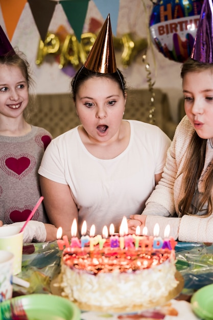Girls blowing candles on tasty cake