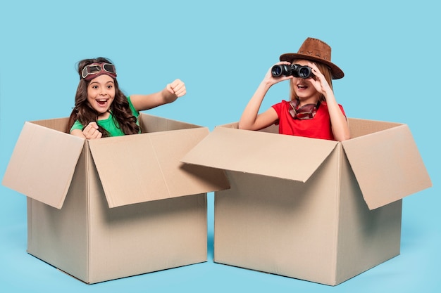 Girls in cartoon boxes playing explorers