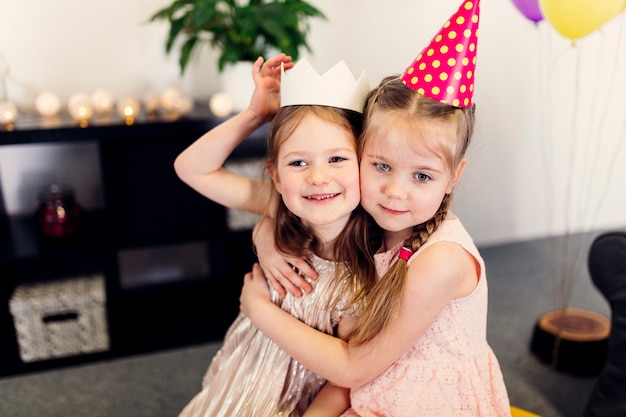 Girls in colored caps hugging