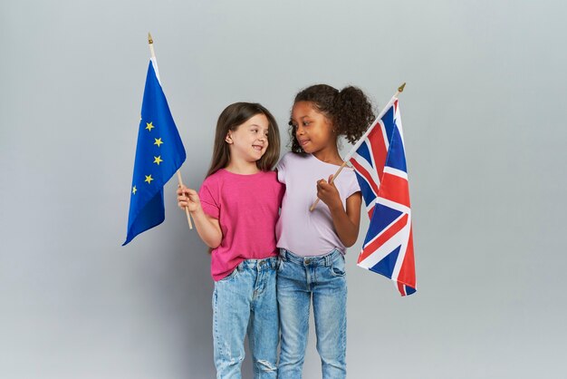 英国と欧州連合の旗を抱きしめて保持している女の子