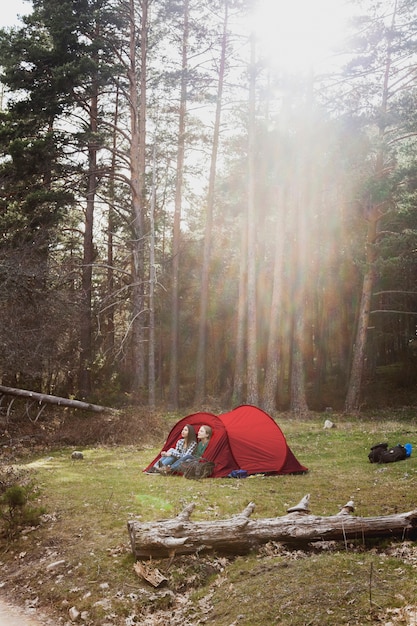 Девушки наслаждаются природой в красной палатке