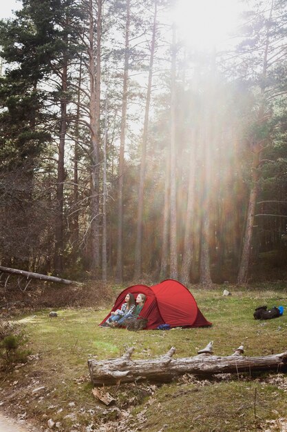 Girls enjoying nature in a red tent