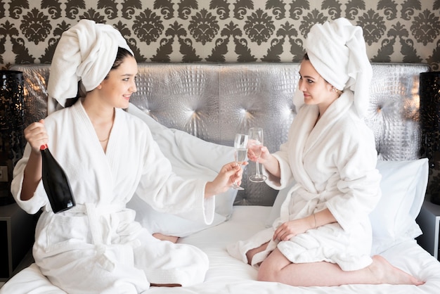 Girls enjoying spa day with a bottle of champagne 