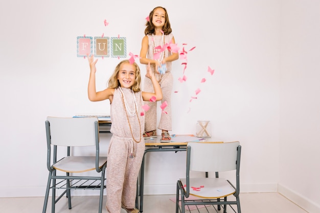 Free photo girls under falling paper pieces