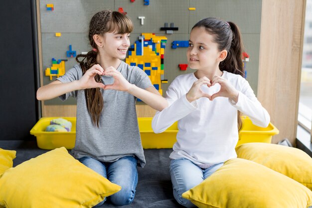 Girls forming heart with hands