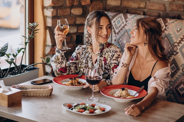 Girls friends eating pasta in an italian restaurant