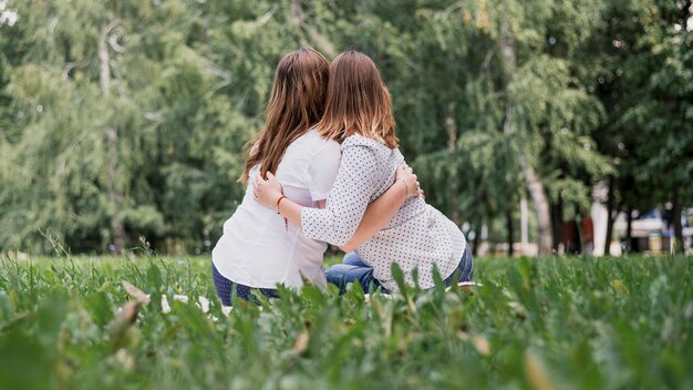 Girls from behind hugging each other