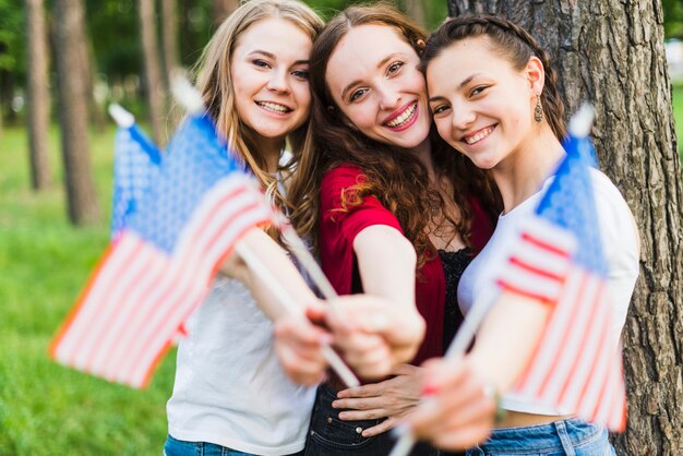 Girls in front of tree with american flags