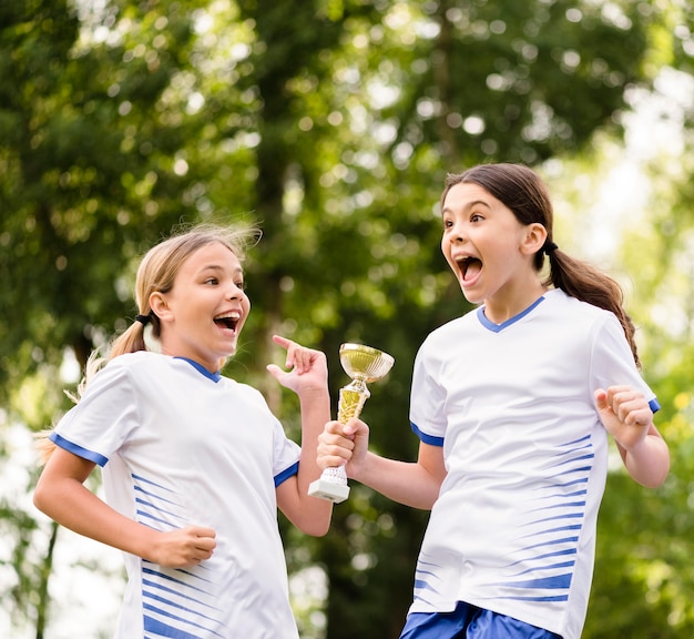 サッカーの試合に勝った後にトロフィーを獲得した女の子