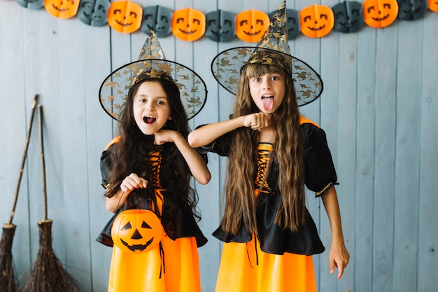 Free photo girls in halloween costumes pretending killing themselves