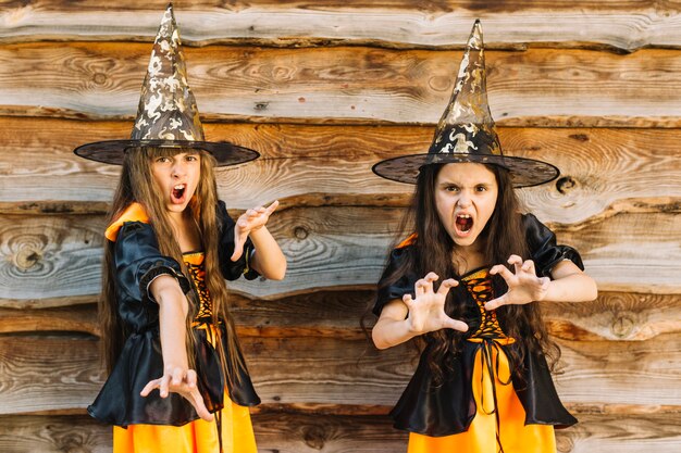 Girls in Halloween costumes pretending wicked spell