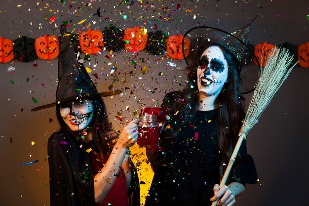 Девушки на вечеринке на Хэллоуин с конфетти