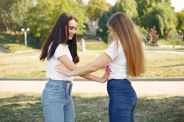 girls having fun in a park with holi paints