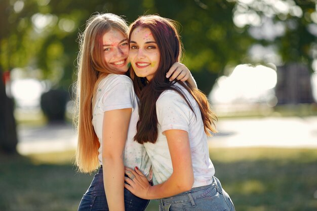 girls having fun in a park with holi paints