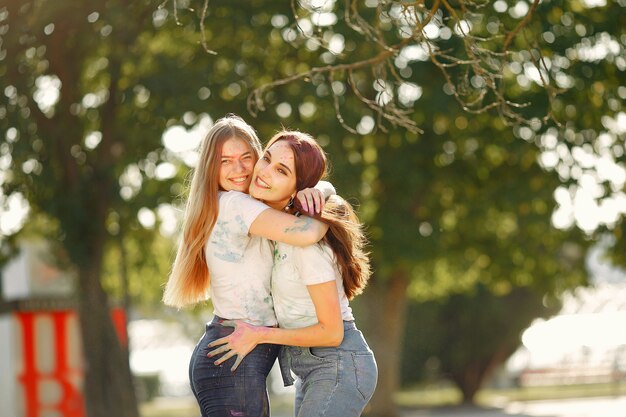 girls having fun in a park with holi paints