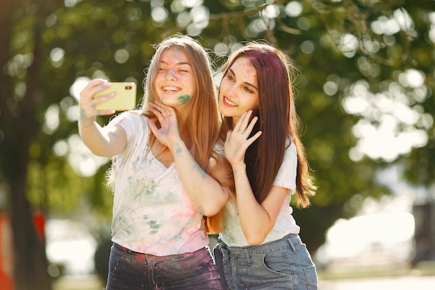 девушки веселятся в парке с красками Холи