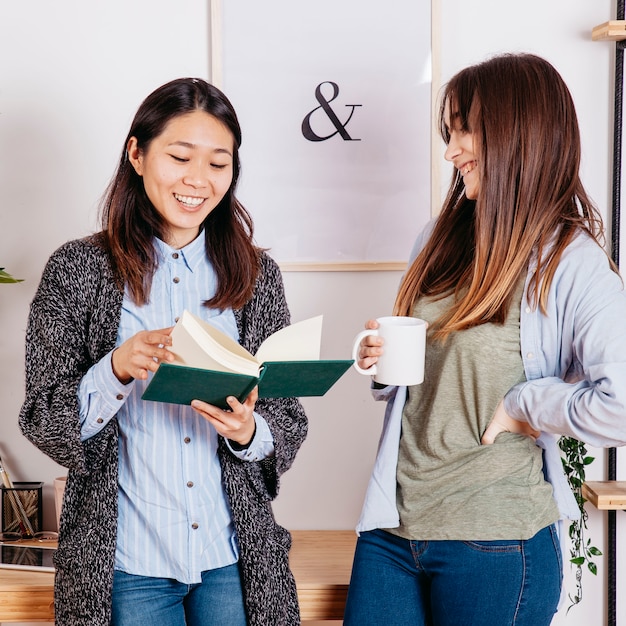 Foto gratuita ragazze che si divertono e condividono il libro