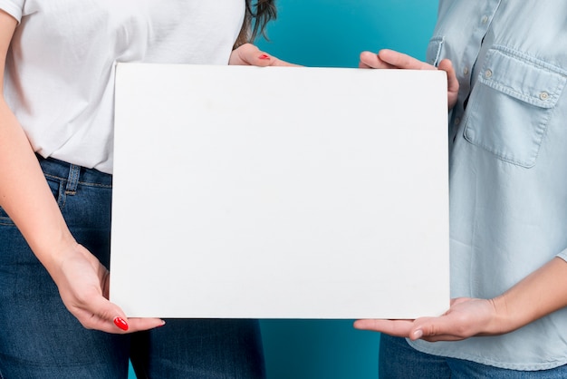 Free photo girls holding blank board