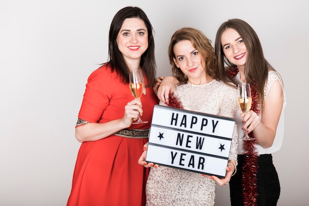 Foto gratuita ragazze in possesso di felice anno nuovo segno