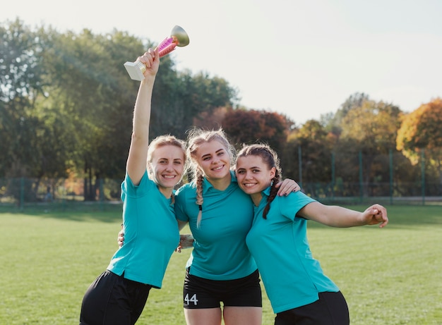 Girls holding a sport trophy and looking at photographer