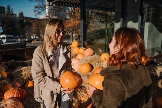 Girls holds pumpkins in hands