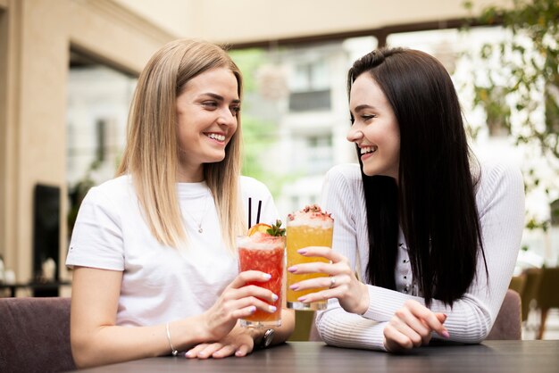 Girls indoors toasting with their cocktails