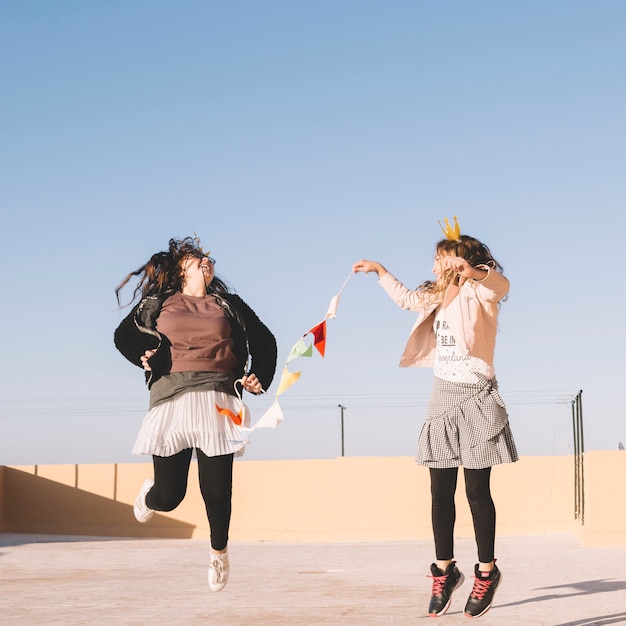 Free photo girls jumping with garland