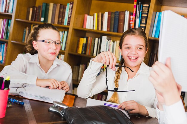 Girls laughing at picture in school copybook 