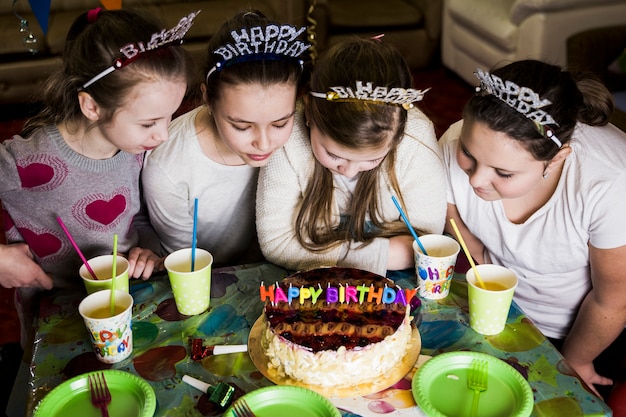 Бесплатное фото Девушки смотрят на торт ко дню рождения