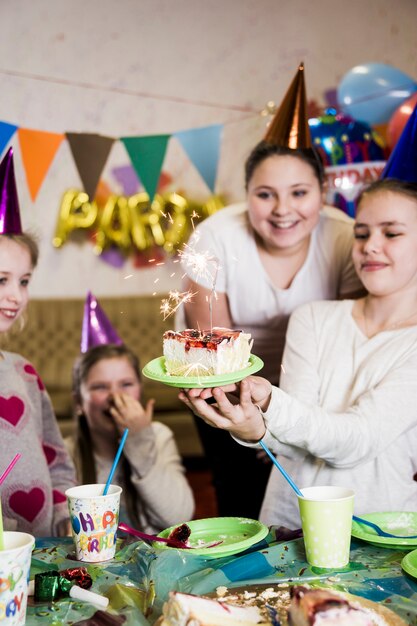 Girls looking at cake with sparkler