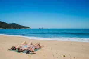 Free photo girls lying at the shoreline