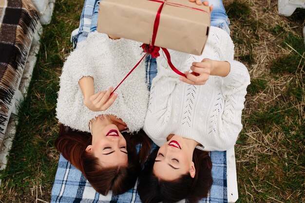 Girls lying on their backs with a brown gift