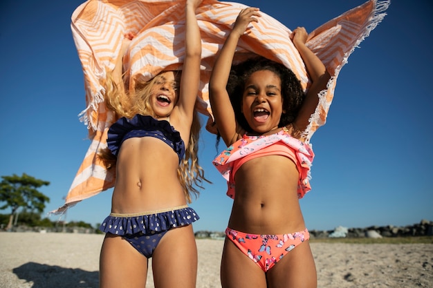 Девушки играют на пляже под низким углом