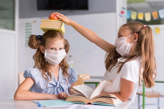 医療用マスクを着用しながらクラスで遊ぶ女の子